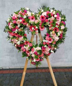 Wieniec pogrzebowy w kształcie serca z kwiatów w różnych kolorach